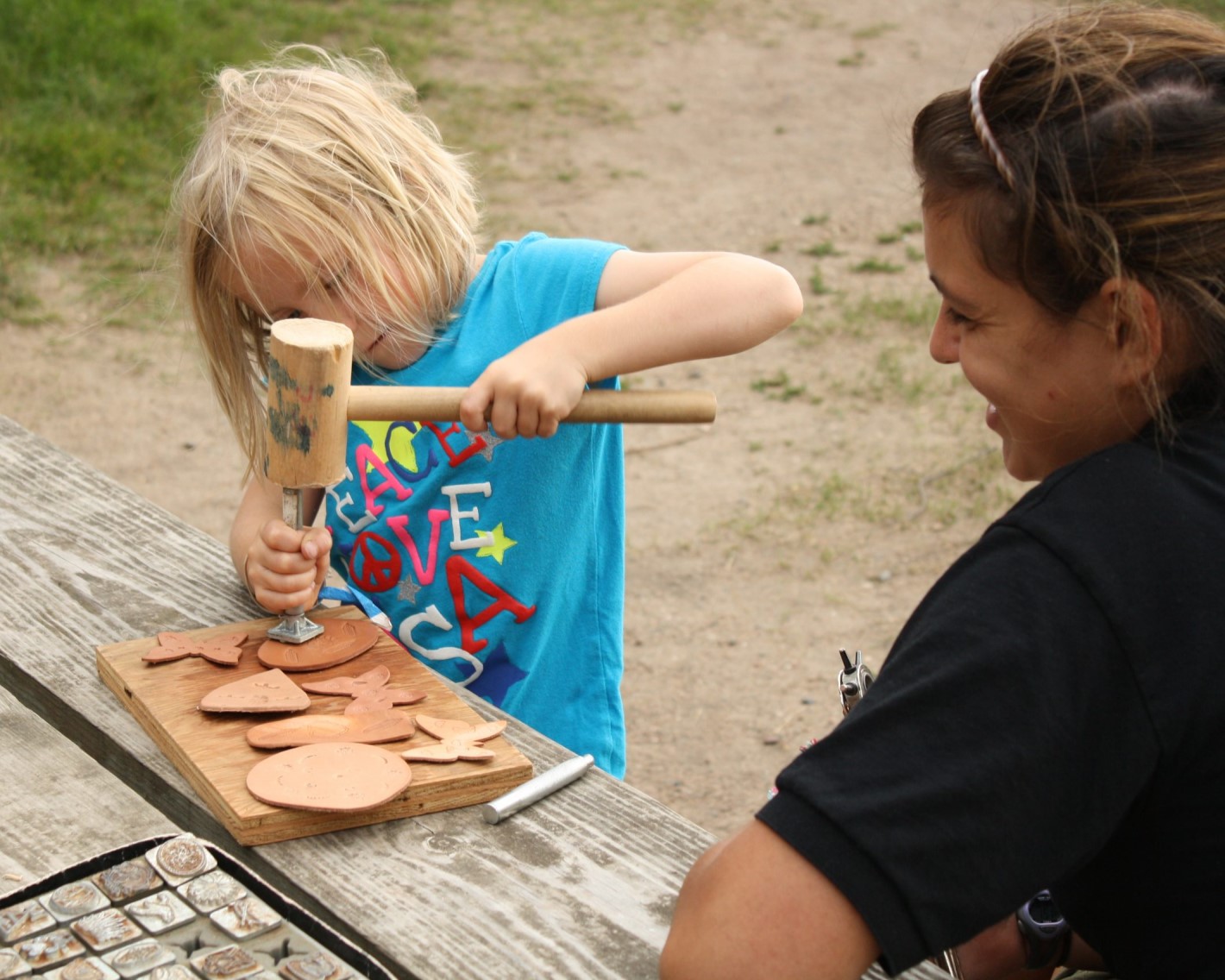 Family Camp participant hammering a stamp into leather