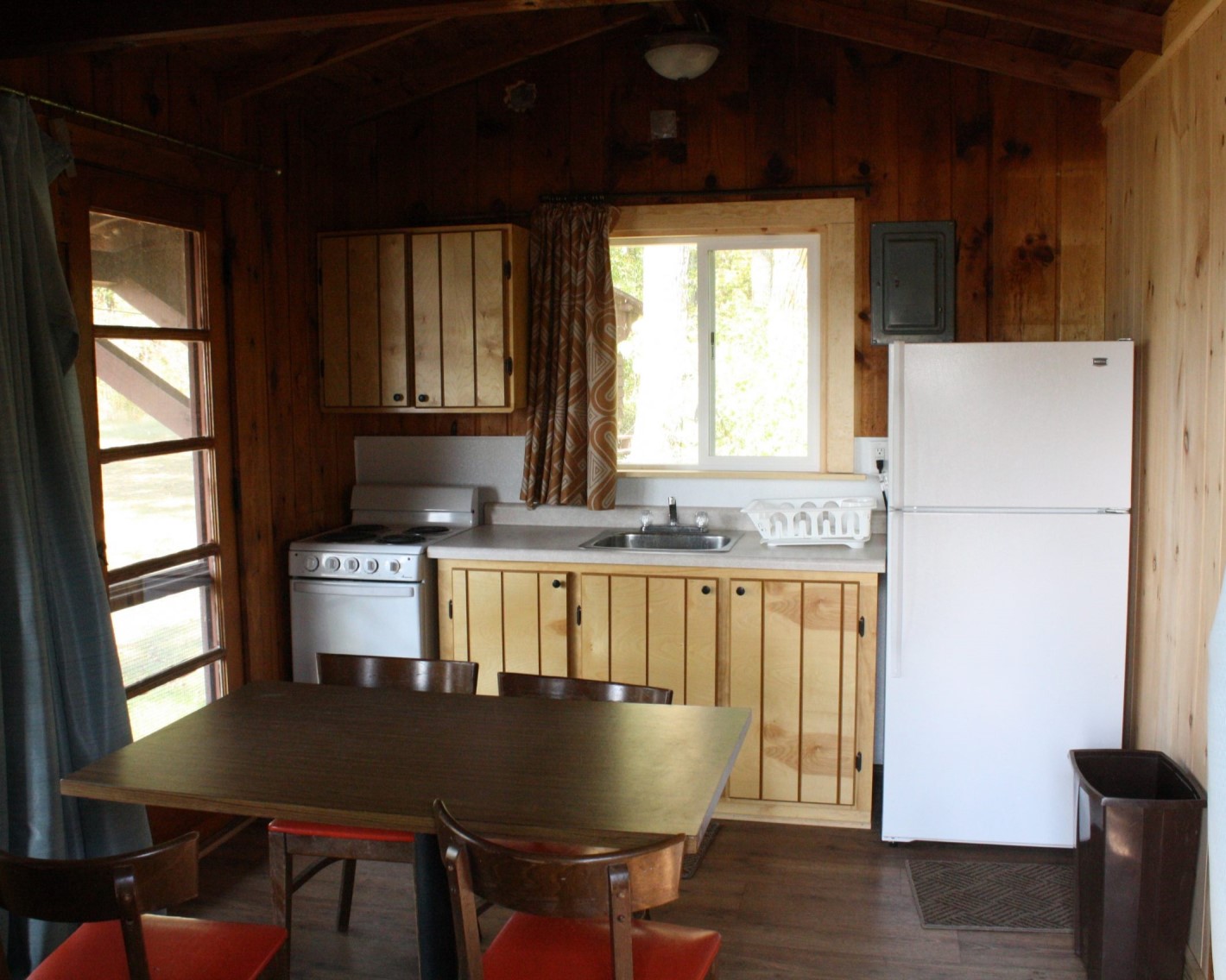 Picture of the cabin kitchen, showing an oven and fridge with a small counter space