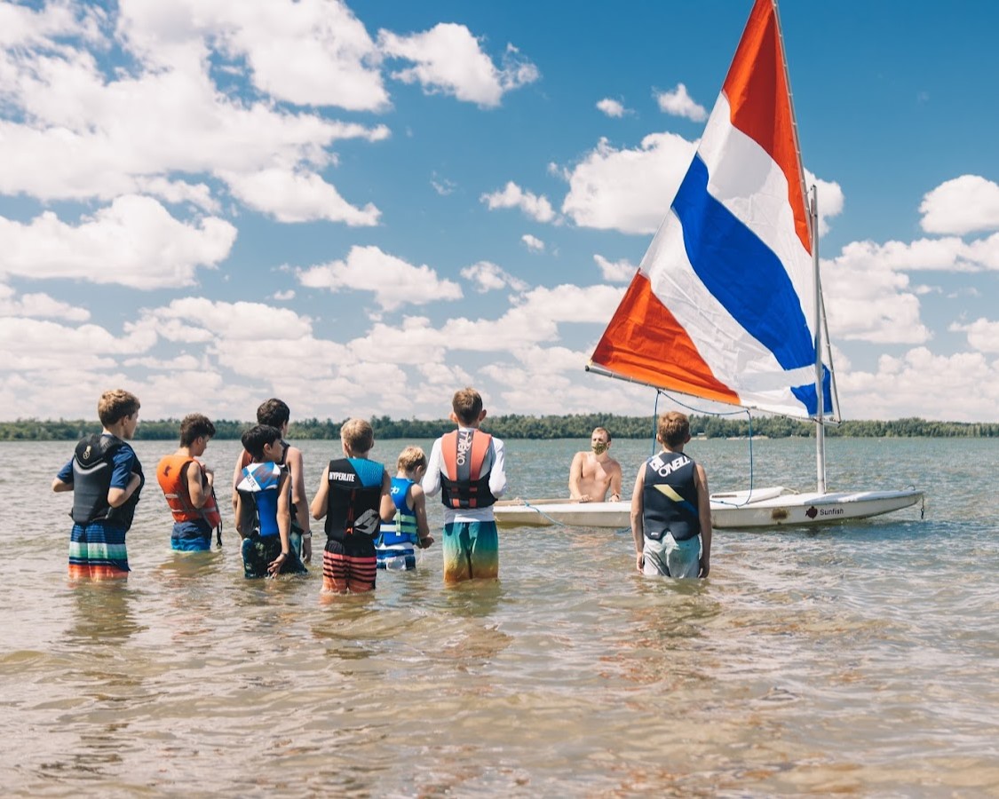 A group of Scouts standing in the water are watching the instructor